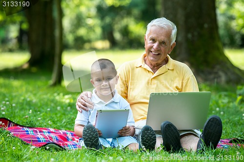 Image of grandfather and child using laptop