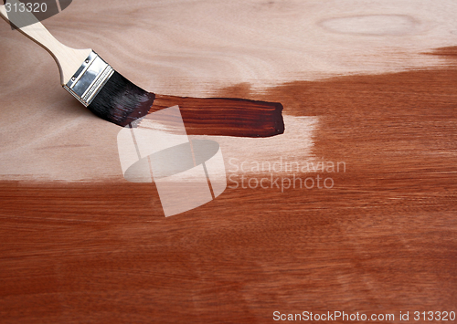 Image of Painting a wooden surface with a brush