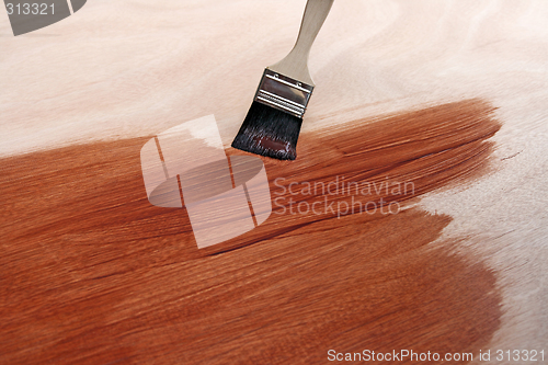 Image of Newly painted wooden surface and brush