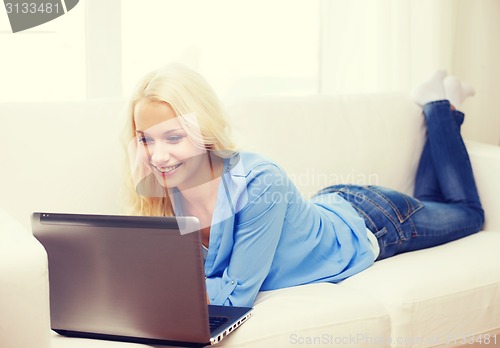 Image of smiling woman with laptop computer at home