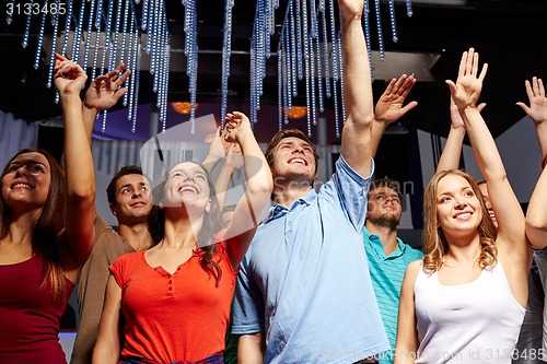 Image of group of smiling friends at concert in club