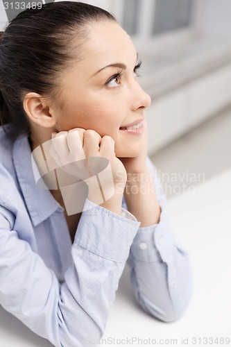 Image of smiling businesswoman dreaming in office