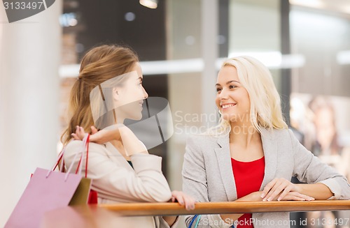 Image of happy young women with shopping bags in mall