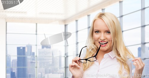 Image of smiling businesswoman or secretary in office