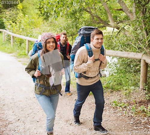 Image of group of smiling friends with backpacks hiking