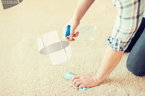 Image of close up of male cleaning stain on carpet