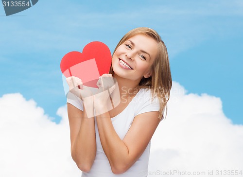 Image of smiling woman in white t-shirt holding red heart