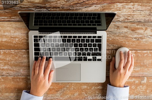 Image of close up of female hands with laptop and mouse