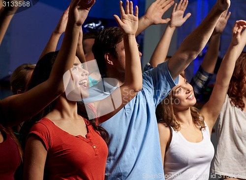 Image of smiling friends at concert in club