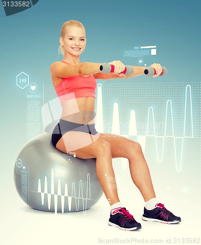 Image of woman with dumbbells sitting on fitness ball