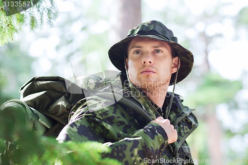 Image of young soldier with backpack in forest