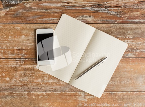 Image of close up of notebook, pen and smartphone