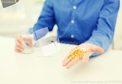 Image of close up of male hand showing lot of pills