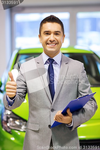 Image of man showing thumbs up at auto show or car salon