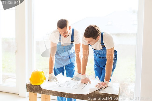 Image of group of builders with blueprint