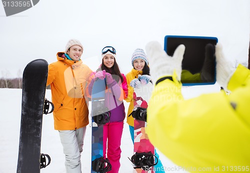 Image of happy friends with snowboards and tablet pc