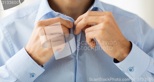 Image of close up of man in shirt dressing 