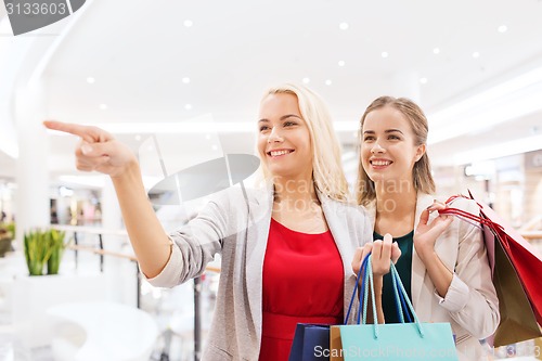 Image of happy young women with shopping bags in mall