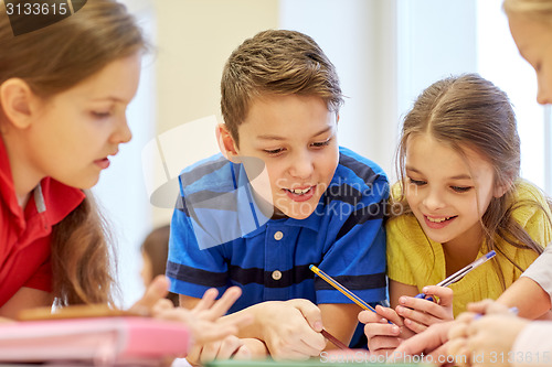 Image of group of students talking and writing at school