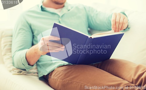 Image of close up of man reading book at home