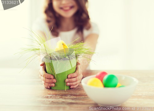 Image of close up of girl holding pot with green grass