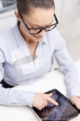 Image of smiling businesswoman with tablet pc in office