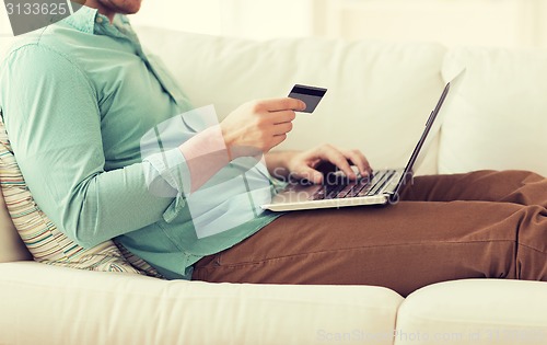 Image of close up of man with laptop and credit card
