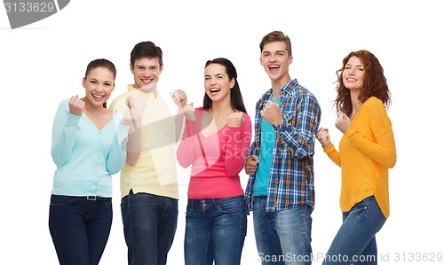 Image of group of smiling teenagers showing triumph gesture