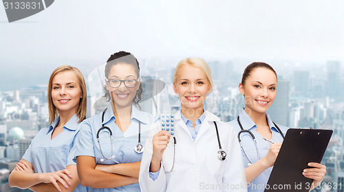 Image of smiling female doctor and nurses with stethoscope