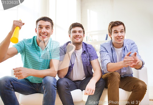 Image of happy male friends with vuvuzela