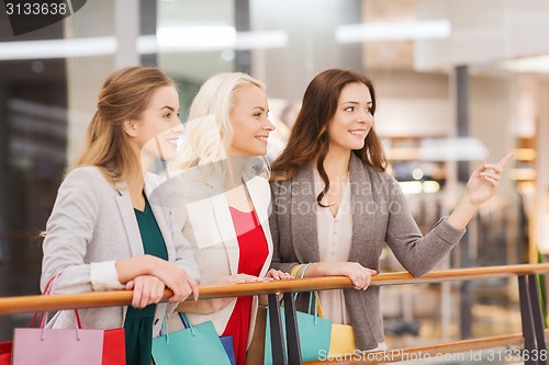 Image of happy young women with shopping bags in mall