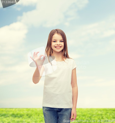 Image of little girl in white t-shirt showing ok gesture