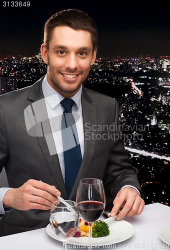 Image of smiling man eating main course