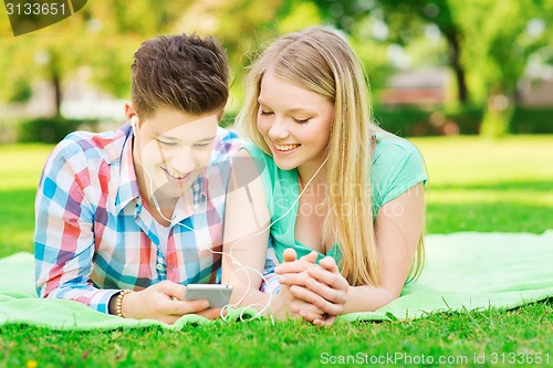 Image of smiling couple with smartphone and earphones