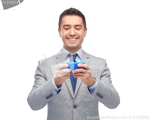 Image of happy businessman texting on smartphone