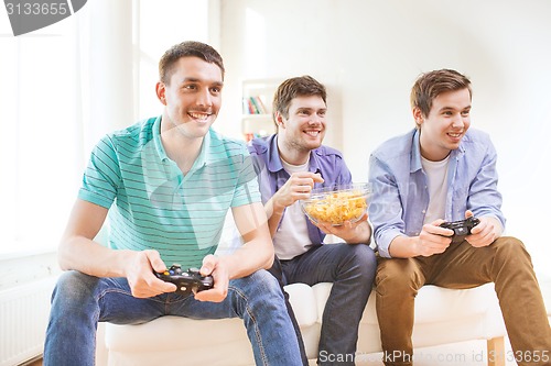 Image of smiling friends playing video games at home