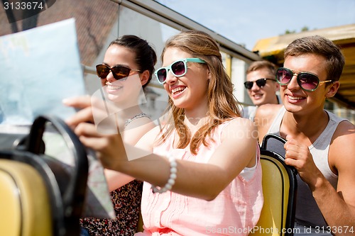 Image of group of smiling friends traveling by tour bus