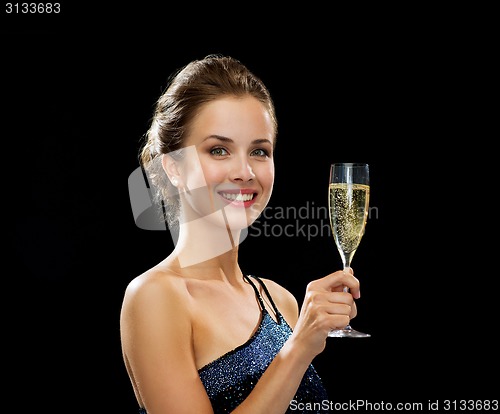 Image of smiling woman holding glass of sparkling wine