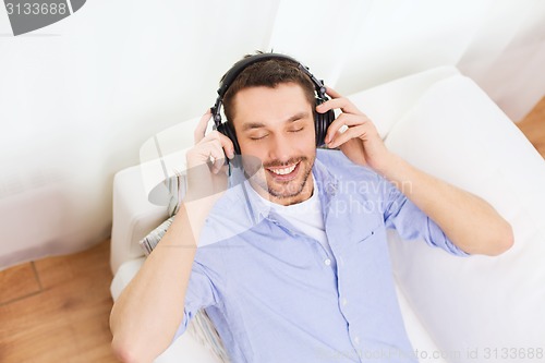 Image of smiling young man in headphones at home