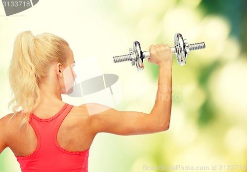 Image of sporty woman with heavy steel dumbbell from back