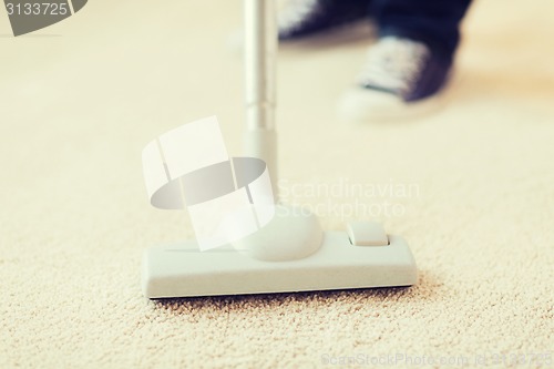 Image of close up of male hoovering carpet