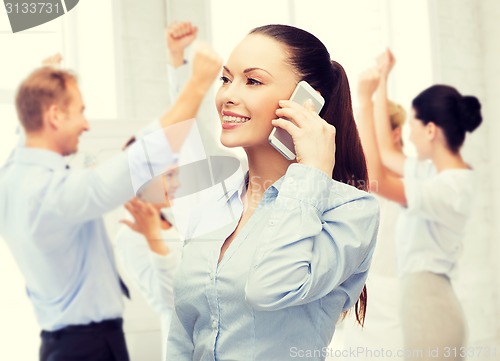 Image of young smiling businesswoman with smartphone