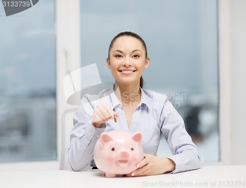 Image of smiling woman with piggy bank and cash money