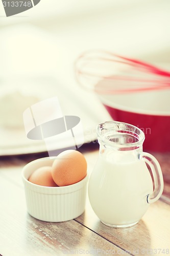 Image of jugful of milk, eggs in a bowl and flour