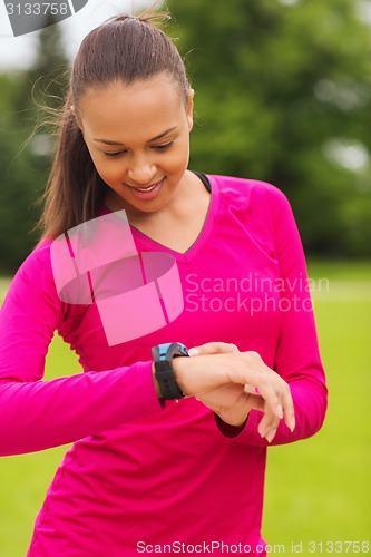Image of smiling young woman with heart rate watch