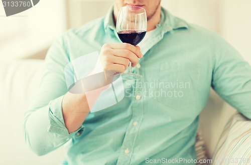 Image of close up of man drinking wine at home