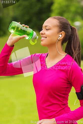 Image of smiling woman with player drinking from bottle