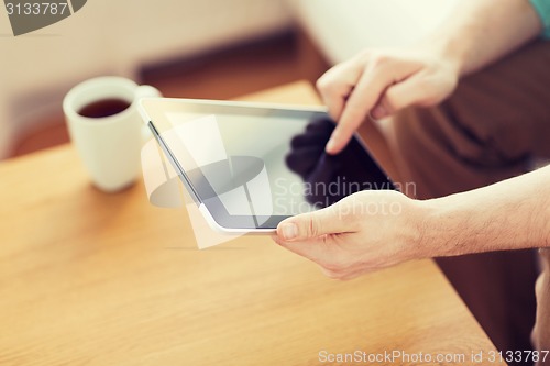 Image of close up of man with laptop and cup at home