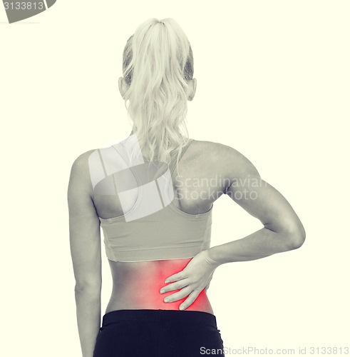 Image of sporty woman touching her back