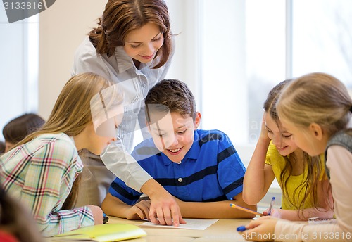 Image of group of school kids writing test in classroom